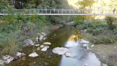İnsansız hava aracı, Ribnica nehrinin sığ bir köprüsünü yakalıyor.