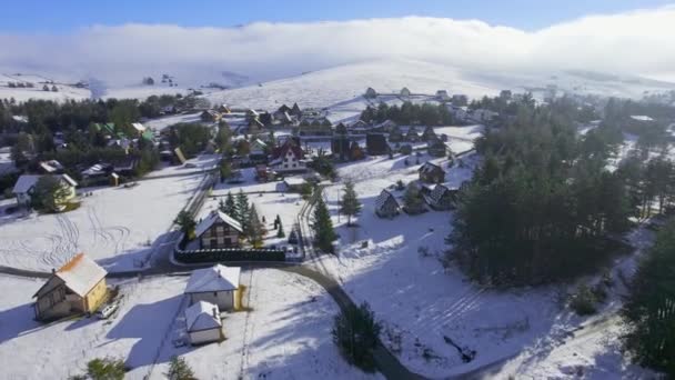 无人机飞过白雪覆盖的旅游村到处都是小木屋和平房 — 图库视频影像