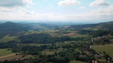 Tarımsal tarlaları ve ormanları olan bir dağın kırsal kesimine ait görüntüler.