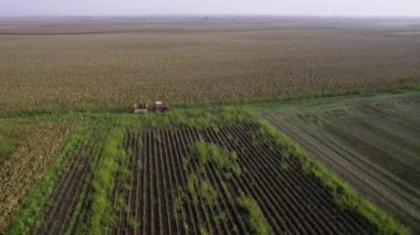 Yoldan geçen insanlarla dolu bir römork ile kırsal kesimin drone görüntüleri.