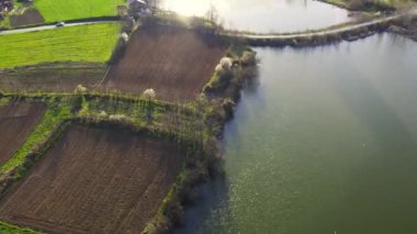 Güneşli göl ve çevresini çevreleyen kırsal bölge.