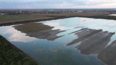 Tarımsal tarlalarla çevrili kırsal bir göl.