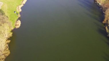 Etrafını çevreleyen göl ve karanın sakin, parlak yüzeyinin havadan görünüşü.