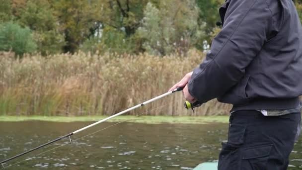 湖から魚を捕まえるためにリールをクランクする男の手の近くのビュー — ストック動画