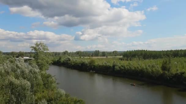 环绕着一座有桥的湖的绿树成荫的土地的惊人的空中画面 — 图库视频影像