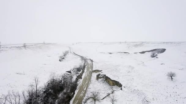 Zamarznięte Koryto Rzeki Otoczone Pokrytą Śniegiem Pagórkowatą Ziemią Jasnym Białym — Wideo stockowe