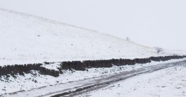 Kışın karla kaplı bir vadide donmuş toprak yol