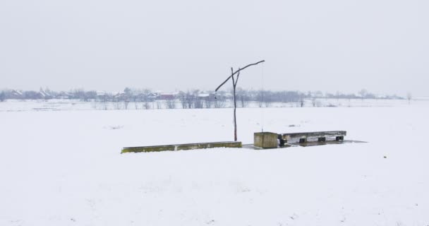 Alte Brunnenpumpe Aus Schneebedecktem Holz Auf Einem Feld — Stockvideo