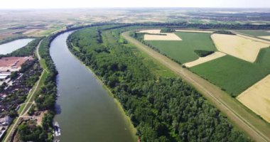 Sırbistan 'da Tisza Nehri' ni çevreleyen yeşil ağaçlar, tarlalar ve evler, hava manzarası