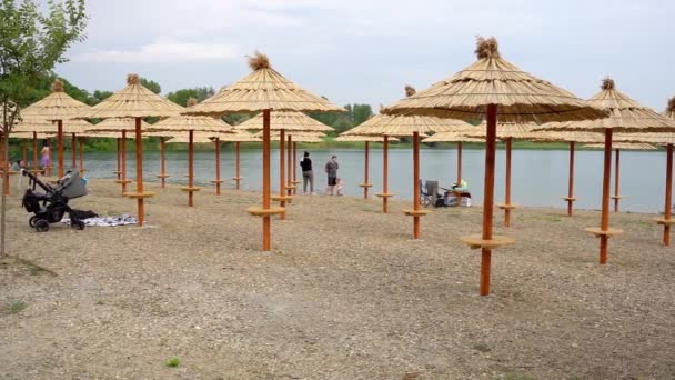Stroh Sonnenschirme Ufer Eines Sees Unkenntlich Menschen Herumstehen — Stockvideo