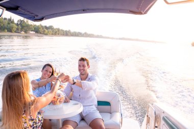 Bir genç adam ve iki güzel kadın şampanya içip teknede eğleniyorlar.