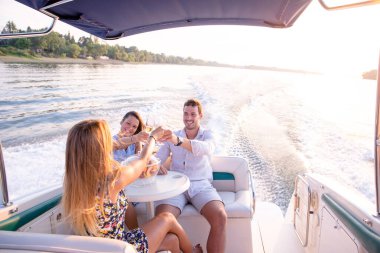 Bir genç adam ve iki güzel kadın şampanya içip teknede eğleniyorlar.