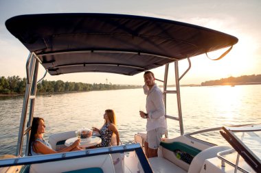 Yattaki arkadaşlar, gülümsüyor ve konuşuyor.