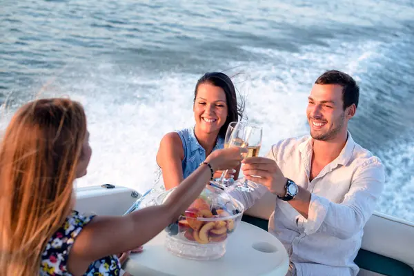 Bir genç adam ve iki güzel kadın şampanya içip teknede eğleniyorlar.
