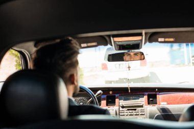 Limuzin sürücüsü aynaya bakıyor.