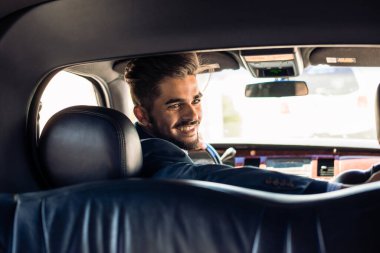 Limuzin şoförü ön koltuktan gülümsüyor.