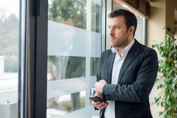 İş adamı pencereden bakıyor.