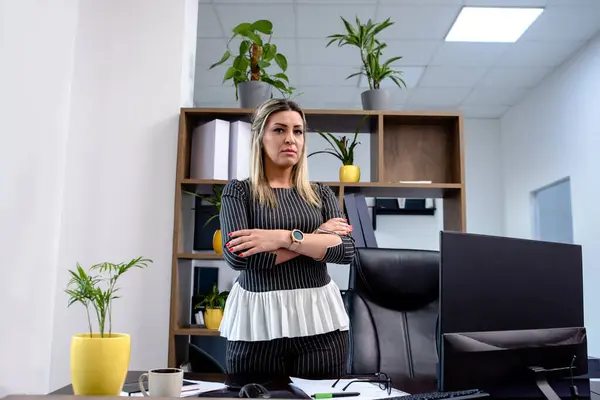 Ofisinde duran sarışın iş kadını.