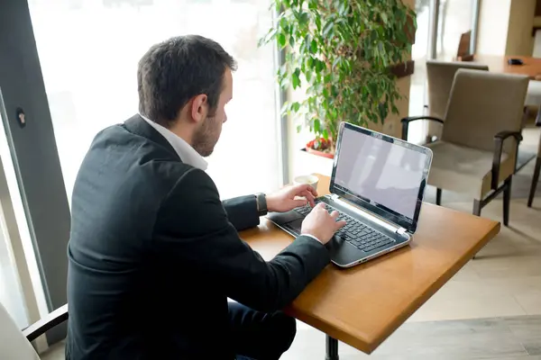 onun bilgisayar üzerinde çalışan iş adamı