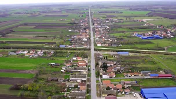 村や田舎を通り抜ける道路付近の農家の空撮映像 — ストック動画