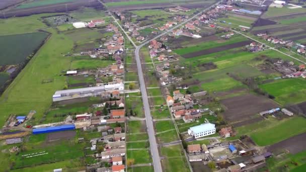 緑の田舎に囲まれた平らな土地の小さな村の航空ビデオ — ストック動画
