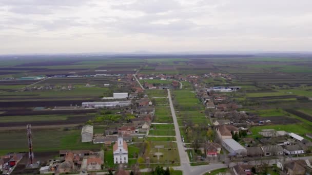Drone Flyger Över Byn Omgiven Lapptäcke Gröna Jordbruksfält — Stockvideo