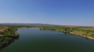 Açık mavi gökyüzünün altındaki temiz göl görüntüsü kırsal kesimde.