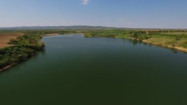 Açık mavi gökyüzünün altındaki temiz gölün güzel hava görüntüleri.