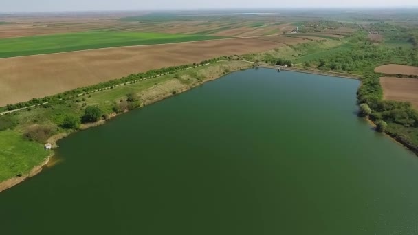 セルビアのセルビアの穏やかな湖の表面に向かってゆっくりと降下するドローン — ストック動画