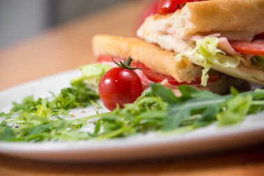 Beyaz tabakta servis edilen kulüp sandviçi.