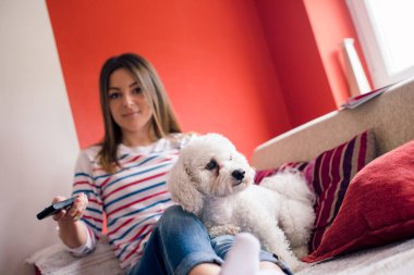 Kız ve evcil hayvanı oturma odasında kanepede.