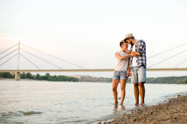 Erkek arkadaşı ve kız arkadaşı kumsalda yürüyor, romantik bir sahne.