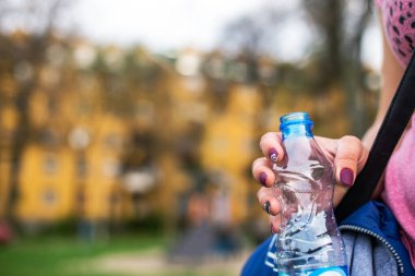 Plastik su şişesi tutan kadın, yaklaşın.