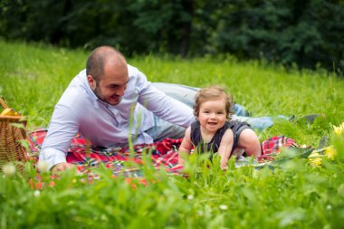 Baba ve kız çayırda piknik yapıyorlar.