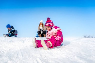 Kız karda eğleniyor.