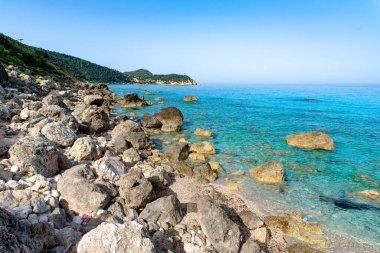 Temiz turkuaz suyu ve egzotik varış yeri olan vahşi, huzurlu kayalık bir plaj.