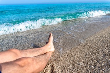Turkuaz sahilde bacak bacak bacak üstüne atmış temiz suyun yanında rahatla.
