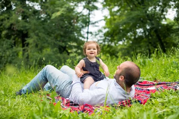 Baba ve kızı doğada oynuyorlar.