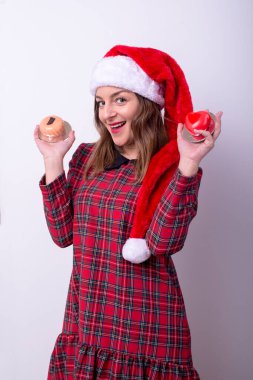 Noel şapkası ve pastası olan hoş bir genç kadın.