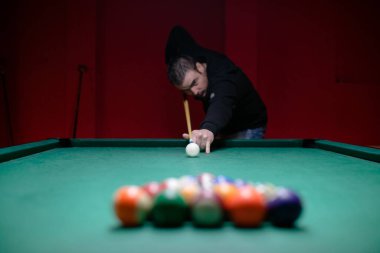 Çekici genç adam bilardo oynuyor.