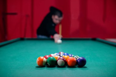 Çekici genç adam bilardo oynuyor.