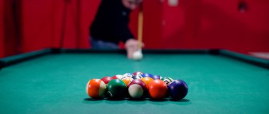 Çekici genç adam bilardo oynuyor.