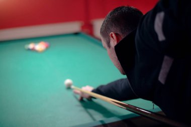 Adam bilardo oynuyor.