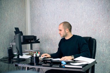 İşadamı ofisinde masaüstü bilgisayarı üzerinde çalışıyor..