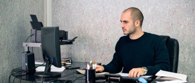 Ofis masasında çalışan genç iş adamının kırpılmış görüntüsü, bilgisayar, masa başı ofis malzemeleri..