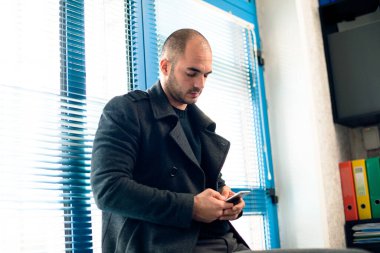 İşadamı ofiste mesaj atıyor, işle ilgili kaygılanıyor..