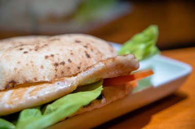 Izgara tavuk göğsünü hamburger, marul ve domatesle kapat..