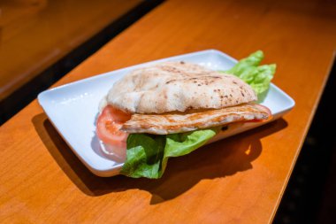 Hamburgerin yanına ızgara tavuk ve salata koy..