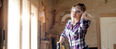 Genç ve çekici sarışın kadın marangoz atölyesinde çalışıyor.