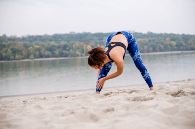 Genç bir kadın sahilde ısınıyor, bacaklarını açıyor..
